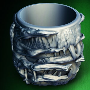 Pu&ograve; includere: Una tazza color argento con un design testurizzato a forma di mostro. La tazza &egrave; realizzata per assomigliare alla bocca di una creatura con denti affilati.