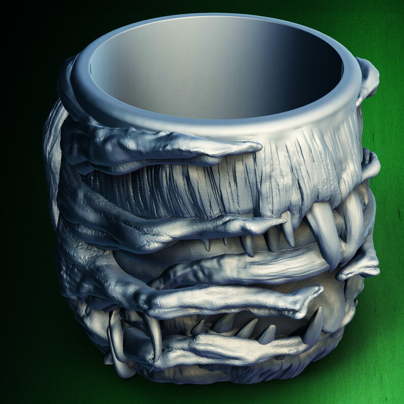 Pu&ograve; includere: Una tazza color argento con un design testurizzato a forma di mostro. La tazza &egrave; realizzata per assomigliare alla bocca di una creatura con denti affilati.