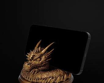 May include: A gold dragon phone stand. The dragon is intricately detailed with horns and scales. The stand is designed to hold a black smartphone, blending fantasy and modern technology. The stand is approximately 10 cm in diameter.