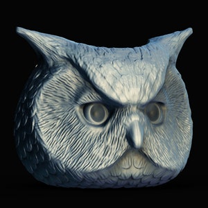 May include: A detailed, gray owl sculpture with a fierce expression. The owl's eyes are wide open and its beak is slightly open. The sculpture is made of a smooth, textured material.