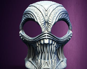 Könnte beinhalten: Eine silberfarbene Maske mit einem detaillierten, komplizierten Design. Die Maske hat einen breiten, offenen Mund mit scharfen Zähnen und zwei große, runde Augenlöcher.