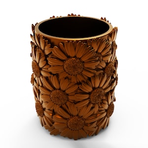 May include: A gold-colored metal vase with a decorative design of overlapping sunflowers.