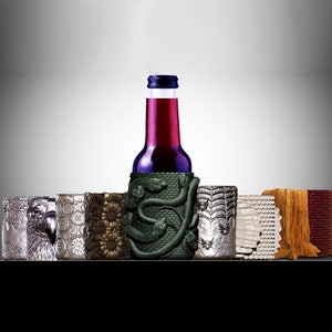 May include: A set of six different beverage coolers, including a snake design cooler for a bottle of red wine, a silver eagle design, a silver floral design, a sunflower design, a spider web design, and a wood grain design.