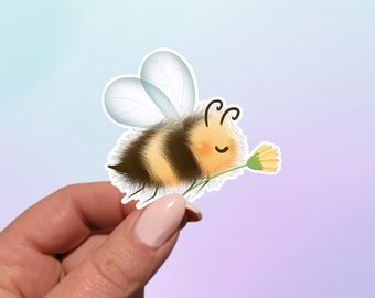 May include: A cute cartoon bumblebee with black and yellow stripes holding a yellow flower. The bumblebee has a happy expression and is surrounded by a light blue and purple background.