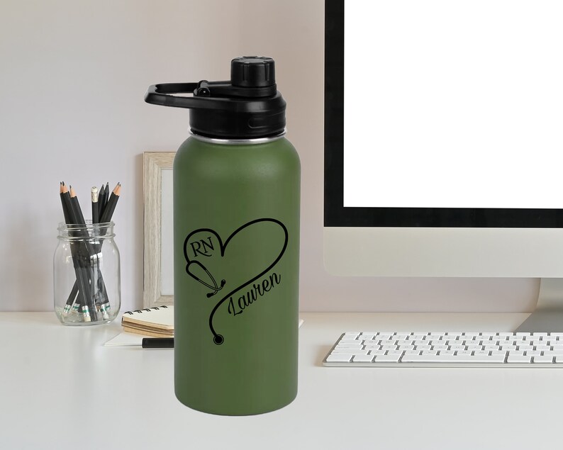 May include: Green stainless steel water bottle with a black lid and handle. The bottle has a black design of a stethoscope in the shape of a heart with the text "RN Lauren" on it.