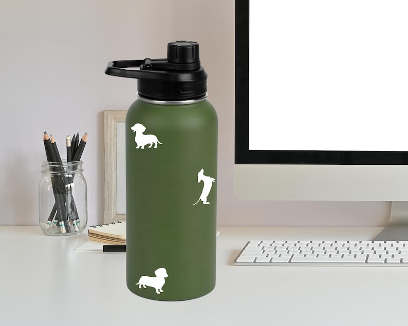 May include: A green stainless steel water bottle with a black lid and three white dachshund silhouettes.