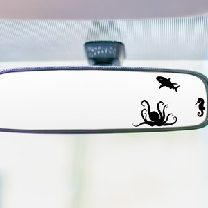 May include: A rearview mirror with a black octopus, shark, and seahorse silhouette decal.