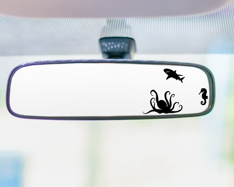 May include: A rearview mirror with a black octopus, shark, and seahorse silhouette decal.
