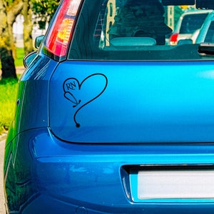 May include: A blue car with a black heart sticker that says "RN" inside the heart. The heart is formed by a stethoscope.