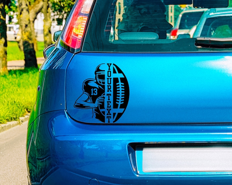 May include: Black and white decal of a football player holding a football with the text "YOUR TEXT" on a blue car.