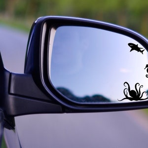 May include: A rearview mirror with a black octopus, a black shark, and a black seahorse silhouette sticker on the glass.