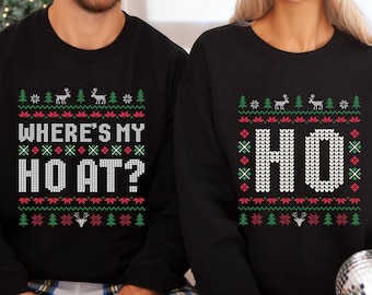May include: Black sweatshirts with a festive Christmas design. One sweatshirt reads "WHERE'S MY HO AT?" and the other reads "HO". The design includes reindeer, trees, and decorative patterns in red, green, and white.