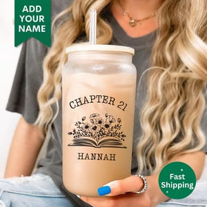 May include: A clear reusable tumbler with a black and white design featuring a book with flowers and the text "Chapter 21 Hannah".