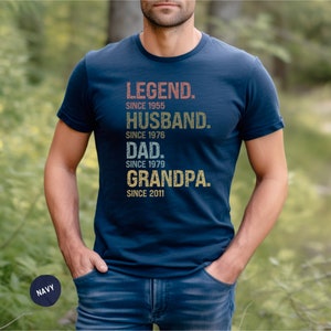K&ouml;nnte beinhalten: Ein marineblaues T-Shirt mit einer Grafik im Vintage-Stil, auf dem "LEGEND. SINCE 1955 HUSBAND. SINCE 1976 DAD. SINCE 1979 GRANDPA. SINCE 2011" steht.
