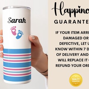 May include: A white stainless steel tumbler with a blue and pink striped design. The tumbler has the name "Sarah" and a pair of baby footprints with hearts on it. The text "Happiness Guarantee" is on the background.
