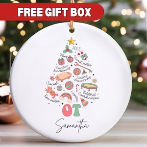May include: White ceramic ornament shaped like a Christmas tree with a pink and green OT logo and the name Samantha. The tree is decorated with colorful illustrations of activities related to occupational therapy, including play, fine motor, visual motor, sensory processing, cognition, bilateral coordination, and executive functioning.