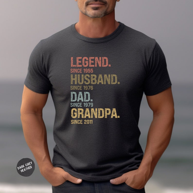 K&ouml;nnte beinhalten: Dunkelgraues T-Shirt aus Heather-Material mit einer Grafik im Vintage-Stil, auf der "LEGEND. SINCE 1955 HUSBAND. SINCE 1976 DAD. SINCE 1979 GRANDPA. SINCE 2011" steht.