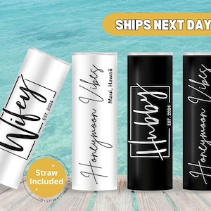 May include: Three stainless steel tumblers with black and white text. The tumblers are labeled "Wifey", "Hubby", and "Honeymoon Vibes Maui, Hawaii".
