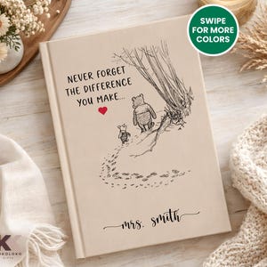 May include: A beige hardcover book with the text "NEVER FORGET THE DIFFERENCE YOU MAKE..." and a Winnie the Pooh illustration. The book also includes the name "mrs. smith" in cursive. A green circle with the text "SWIPE FOR MORE COLORS" is in the upper right corner.