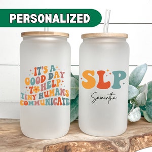 May include: Two frosted glass tumblers with bamboo lids and straws. One tumbler has the text "It's a good day to help tiny humans communicate" in colorful retro font. The other tumbler has the text "SLP Samantha" in colorful retro font.