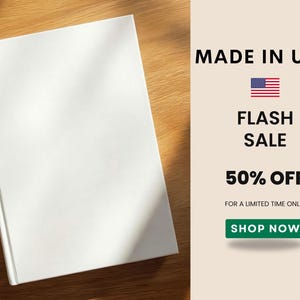 K&ouml;nnte beinhalten: Ein wei&szlig;es Buch mit leerem Einband liegt auf einer Holzoberfl&auml;che. Der Text "MADE IN USA", "FLASH SALE" und "50% OFF" wird neben der amerikanischen Flagge angezeigt. Ein gr&uuml;ner "SHOP NOW"-Button ist ebenfalls sichtbar.