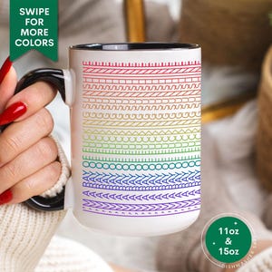 May include: White ceramic mug with a black handle and rim, featuring a rainbow gradient design of various geometric patterns. The mug is available in 11oz and 15oz sizes. Text on the mug reads "SWIPE FOR MORE COLORS".