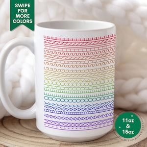 May include: White ceramic mug with a rainbow design of horizontal lines and patterns. The mug has a large handle and the text "SWIPE FOR MORE COLORS" is visible. The mug is available in 11oz and 15oz sizes and is dishwasher safe.