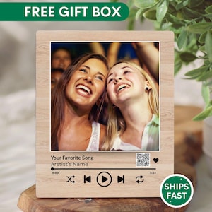 May include: A wooden plaque with a photo of two smiling women. The plaque has a music player interface design with the text "Your Favorite Song" and "Artist's Name." The plaque is a gift and includes the text "FREE GIFT BOX."