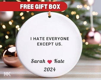 May include: White ceramic Christmas ornament with the text "I hate everyone except us." and the names "Sarah" and "Kate" with a red heart between them. The year "2024" is printed below the names.
