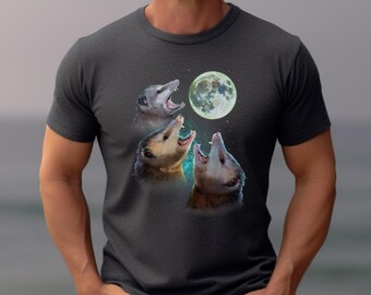 May include: A dark gray t-shirt with a graphic of three opossums howling at the moon. The moon is a light green color.