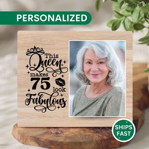 May include: A wooden photo frame with a picture of a woman with gray hair. The frame has the text "This Queen makes 75 look Fabulous" and the word "PERSONALIZED" in green. A "SHIPS FAST" sticker is on the bottom right.