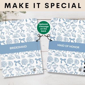 K&ouml;nnte beinhalten: Zwei Spiralnotizb&uuml;cher mit einem Muschelmuster und dem Text "MAKE IT SPECIAL". Ein Notizbuch tr&auml;gt die Aufschrift "BRIDESMAID" und das andere "MAID OF HONOR" auf einem blauen Band. Der Hintergrund ist helles Holz.