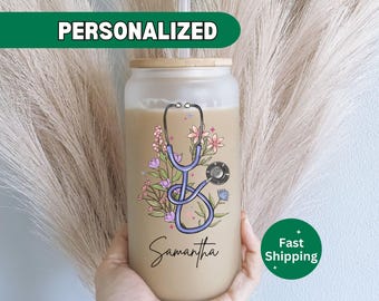 May include: Personalized clear tumbler with a light blue stethoscope and floral design. The tumbler has the name Samantha printed on it.