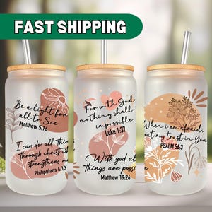 May include: Three frosted glass tumblers with bamboo lids and straws. Each tumbler features a different inspirational quote with bible verses and abstract floral designs in shades of brown and pink.