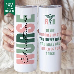 May include: A white stainless steel tumbler with a green and pink design. The tumbler features the text "NURSE" with a name, "CHRISTINA", written vertically in pink. The other side of the tumbler features a green and pink caduceus symbol with the letters "RN" and the text "NEVER UNDERESTIMATE THE DIFFERENCE YOU MAKE AND THE LIVES YOU TOUCH".