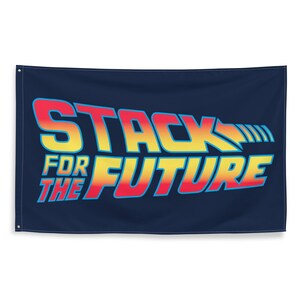 Puede incluir: Una bandera azul marino con el texto "Stack for the Future" en una fuente estilizada con un degradado de amarillo, naranja, rojo y azul.