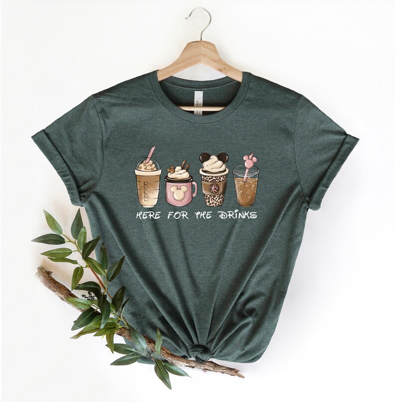 May include: A green t-shirt with a graphic of four different coffee drinks. The text "Here for the drinks" is printed below the drinks.