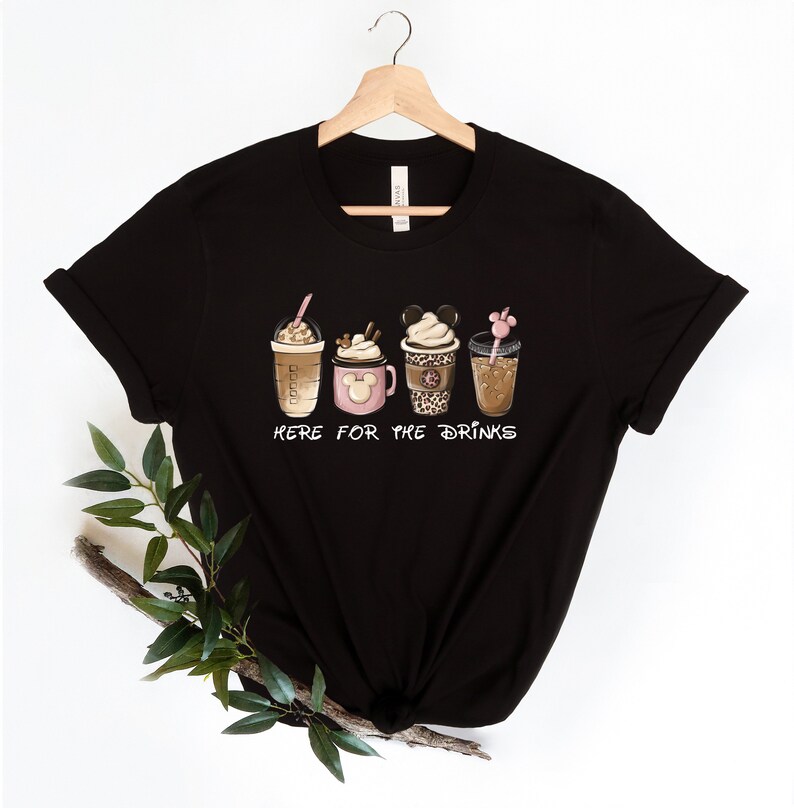 May include: Black t-shirt with a graphic of five different coffee drinks. The text "Here for the drinks" is printed below the drinks.