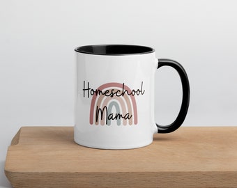 Puede incluir: Taza de café de cerámica blanca con borde y asa negros. La taza presenta un diseño de arcoíris con el texto "Homeschool Mama" en negro.