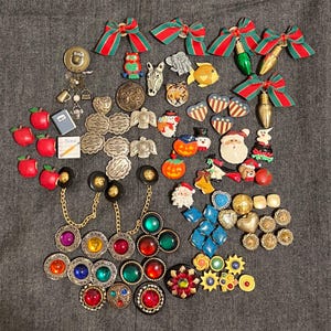 Peut inclure: Une collection de broches et d'épingles vintage de différentes formes et couleurs. Comprend des motifs de pommes, de nœuds et de vacances, ainsi que des motifs de cœurs, floraux et géométriques. Certaines épingles ont des chaînes.