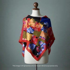 May include: A colorful silk scarf with a floral pattern. The scarf features a patchwork design with red, blue, yellow, and black squares. Large flowers in shades of red, orange, and blue are scattered across the fabric. The scarf is displayed on a mannequin.