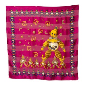 Könnte beinhalten: Ein fuchsiafarbener Seidenschal mit einem sich wiederholenden Muster aus kleinen Figuren in Blau und Weiß. In der Mitte befindet sich eine große gelbe Clownfigur mit Fliege und juwelenartigen Akzenten, umgeben von Sternen und Buchstaben.