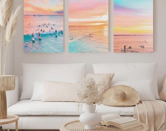 May include: A set of three rectangular wall art prints featuring ocean scenes at sunset. Each print displays surfers on boards in turquoise water under a vibrant sky with gradients of pink, orange, and yellow hues, creating a cohesive coastal display.
