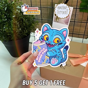 K&ouml;nnte beinhalten: Blauer Cartoon-Katzen-Aufkleber, der eine Soda-Dose mit der Aufschrift "MY LITTLE SODA POP" h&auml;lt. Der Aufkleber ist wasserfest und tr&auml;gt den Text "BUY 5 GET 1 FREE".