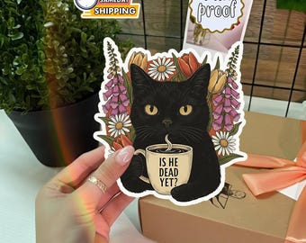 Könnte beinhalten: Ein schwarzer Katzenaufkleber mit gelben Augen, der eine Kaffeetasse mit der Aufschrift "IS HE DEAD YET?" hält, umgeben von Blumen. Der Aufkleber ist wasserfest.
