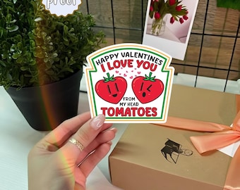 May include: A Valentine's Day sticker with the text "Happy Valentines I Love You From My Head Tomatoes" featuring two cartoon tomatoes. The sticker is labeled "water proof". A gift box with a peach ribbon is in the background.