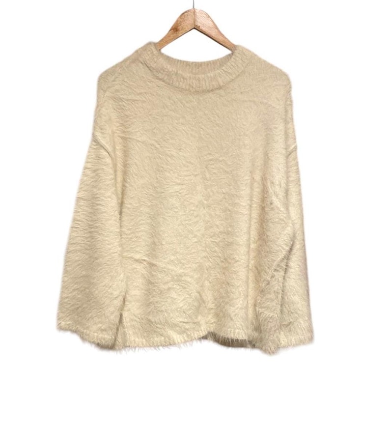 May include: A soft, fluffy, cream-colored sweater with a round neckline and long sleeves.