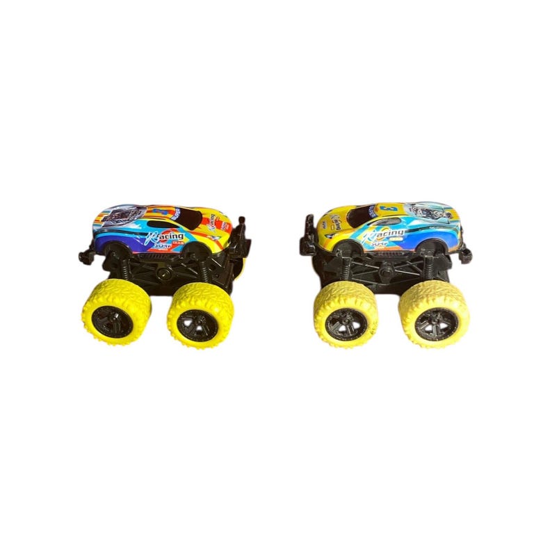 May include: Two toy monster trucks with yellow wheels and black chassis. The truck bodies are decorated with racing graphics in blue, yellow, and red. The word "Racing" is visible on the side of the truck.