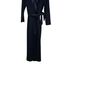 May include: A black jumpsuit with a satin lapel and a tie belt.