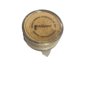 May include: A small, round container of Iredale Mineral Cosmetics Radiant powder. The lid is tan with the word "RADIANT" in the center. The text "TESTER - NOT FOR RESALE" is printed on the lid. The container is filled with a light beige powder.